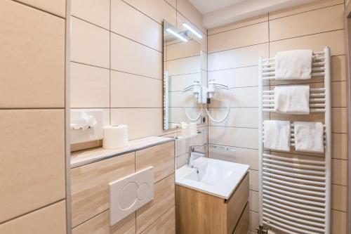 a bathroom with a sink and a mirror at Hotel Restaurant Au Riesling in Zellenberg