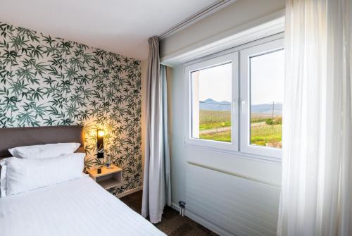 a bedroom with a white bed and a window at Hotel Restaurant Au Riesling in Zellenberg