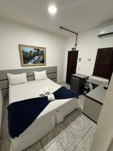 a bedroom with a bed with two shoes on it at Pousada Tambaú in São Luís
