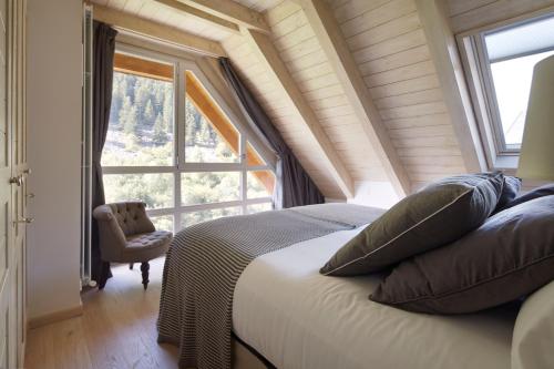 1 dormitorio con cama y ventana grande en Val de Ruda Luxe 44 by FeelFree Rentals, en Baqueira Beret