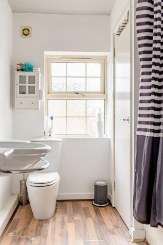 a white bathroom with a toilet and a sink at Main House in Rotherham
