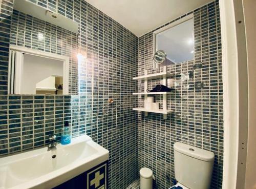 a blue tiled bathroom with a sink and a toilet at Bairro Alto Cozy apartment in Lisbon
