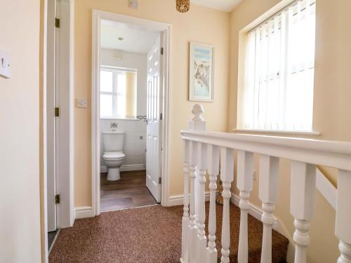 a bathroom with a staircase and a toilet and a window at The Beach Escape in Prestatyn