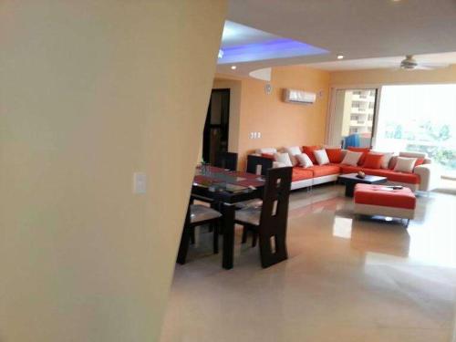 a living room with a couch and a dining room at Playa Almendro Resort in Tonsupa