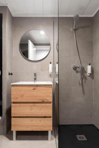 a bathroom with a sink and a shower with a mirror at WOT Costa da Caparica Soul in Costa da Caparica