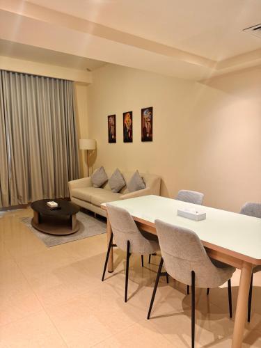 a living room with a table and chairs and a couch at Acacia Hotel Ras Al Khaimah by AMR in Ras al Khaimah