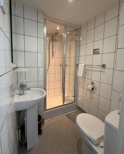 a bathroom with a toilet and a sink and a shower at The Brighton Hotel Seafront in Brighton & Hove