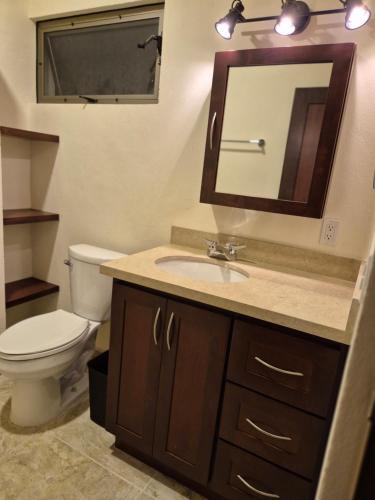 a bathroom with a toilet and a sink and a mirror at Hotel Lorimar in La Paz