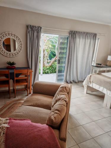 a living room with a couch and a table and a window at 36 Mount Road Guesthouse and Self Catering in Port Elizabeth