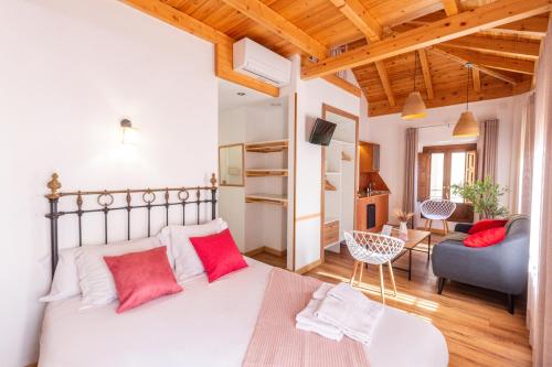 a bedroom with a large bed with red pillows at Casa de la Catedral in Granada