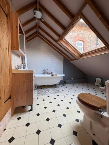 a bathroom with a skylight and a bath tub at Wayeview Cottage on working Devon farm in Ipplepen