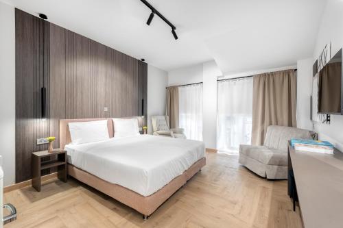 a bedroom with a bed and a couch and a chair at Athenian Heart Suites in Athens