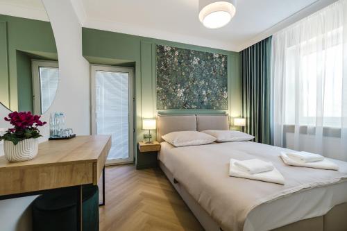 a bedroom with a bed and a desk and windows at Hotel w Dobieszkowie in Stryków