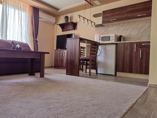 a kitchen and living room with a table and a refrigerator at Пиргуля in General-Toshevo