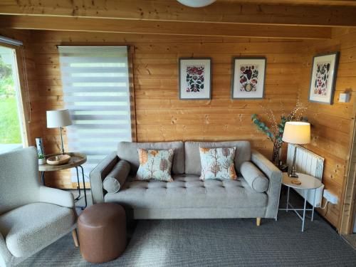 a living room with a couch and a chair at Vineyard lodge in Herefordshire in Ledbury