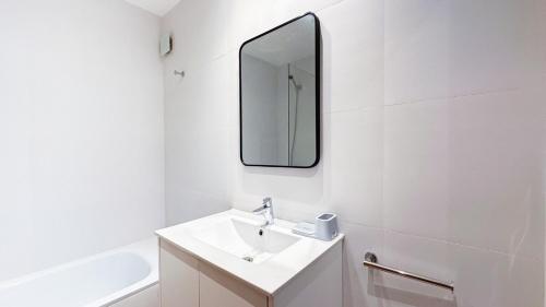 a white bathroom with a sink and a mirror at Hermoso Studio Premium en Microcentro in Buenos Aires