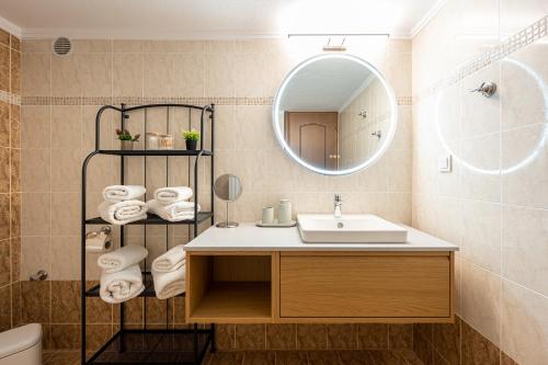 a bathroom with a sink and a mirror and towels at Theatre Home Aegean View in Nea Moudania