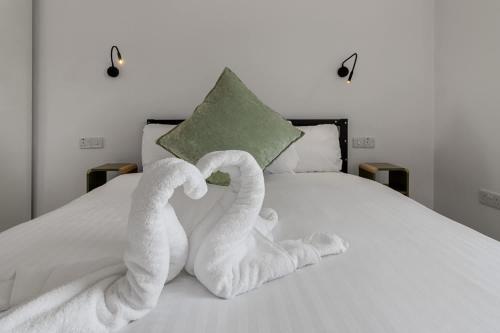 two towels are made to look like swans on a bed at Urban Heights - 2 Bed Apartment - Short Stays UK Ltd in Exeter