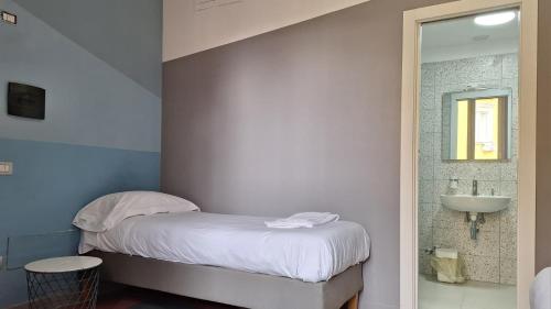 a small bedroom with a bed and a sink at La Controra Hostel Naples in Naples