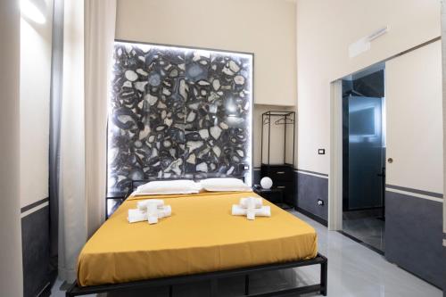 a bedroom with a yellow bed with two white towels at Hotel Torre Orefici in Genoa