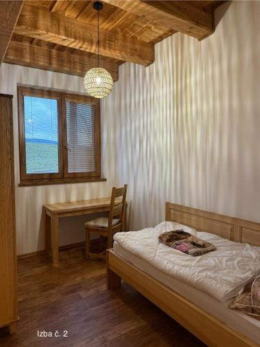 a bedroom with a bed and a table and a window at Slnečný domček Sučany in Sučany
