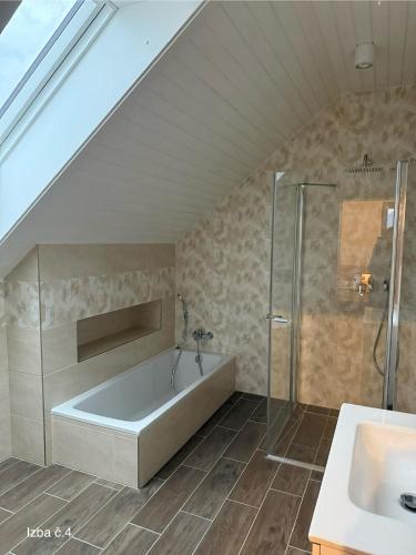 a bathroom with a tub and a shower and a sink at Slnečný domček Sučany in Sučany