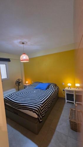 a bedroom with a bed and a yellow wall at Primera Linea de playa in Almería