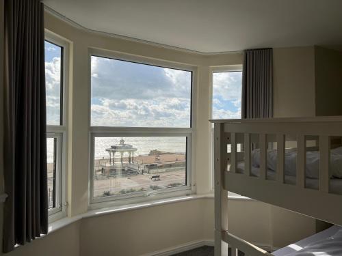 a bedroom with a bunk bed and two windows at The Brighton Hotel Seafront in Brighton & Hove