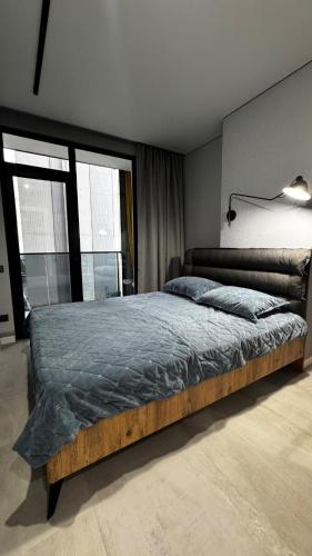 a bedroom with a large bed and a large window at Hostly, New Boulevard Prime Stay in Batumi