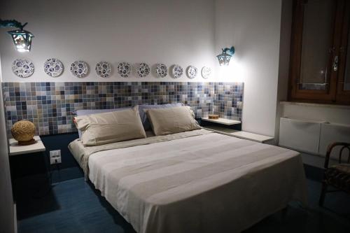 a bedroom with a large bed with plates on the wall at Antonia's Home - casa per le vacanze con giardino e veranda attrezzati in San Domino