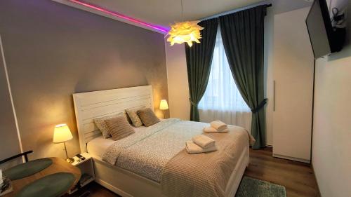 a bedroom with a bed with two towels on it at Clar Studio Residence in Braşov