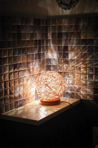 a lamp on a table in a room with a tiled wall at Antonia's Home - casa per le vacanze con giardino e veranda attrezzati in San Domino