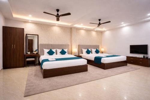 a bedroom with two beds and a flat screen tv at The Vedam Hotels - Ram Mandir Ayodhya A unit of RL Group of Hotels Ayodhya in Ayodhya