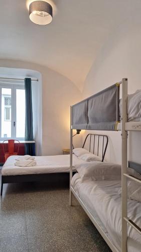two bunk beds in a room with a window at La Controra Hostel Naples in Naples