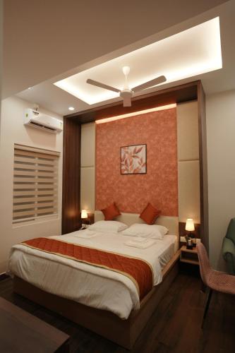 a bedroom with a large bed with a ceiling at Gamagashree Hotel and Fine Dine in Sāgar