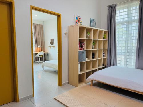 a bedroom with a bed and a book shelf at A home with private pool, KebunStorey in Tangga Batu