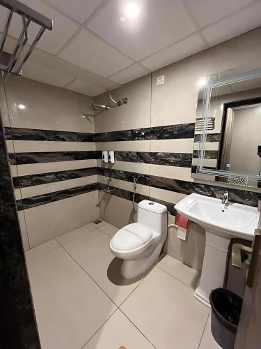 a bathroom with a toilet and a sink at Hotel LG Signature Suites in Bangalore