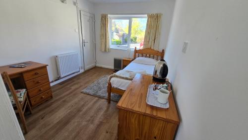 a room with a bedroom with a table and a bed at Snowdonia Mountain Lodge in Bethesda