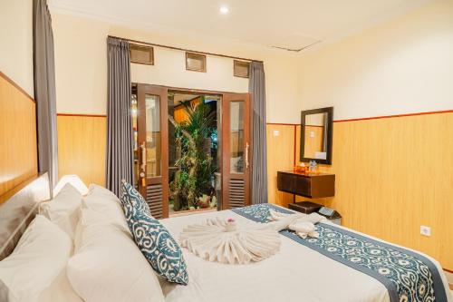 a bedroom with a large white bed and a mirror at Meliora bali villa in Ubud