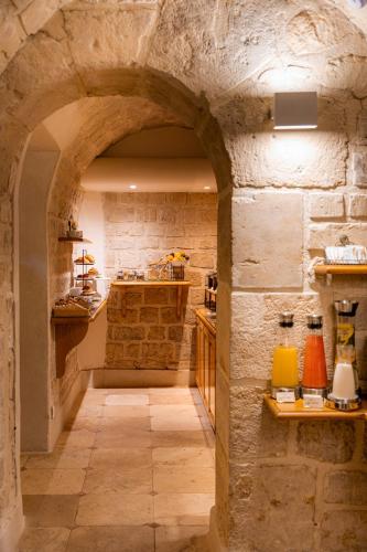 a kitchen with a stone wall and an archway at Hôtel Cordelia Opéra-Madeleine in Paris