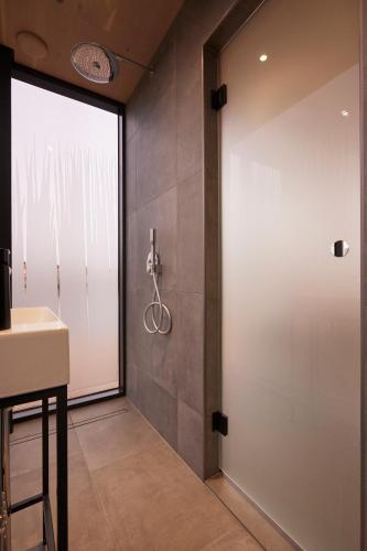 a bathroom with a sliding door and a sink at HANNAH Mirror Tiny House in Den Bosch