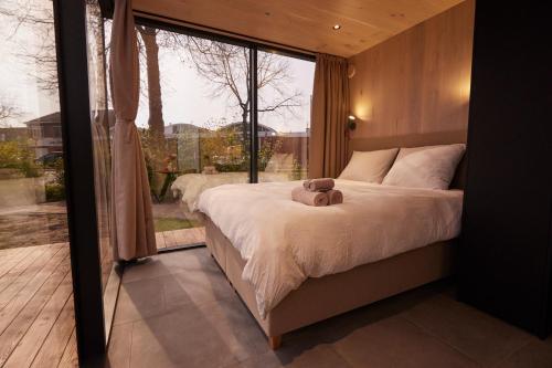 a bedroom with a bed with a teddy bear on it at HANNAH Mirror Tiny House in Den Bosch