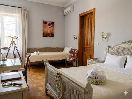 a bedroom with two beds and a living room at Veranda Boutique Hotel Kutaisi in Kutaisi