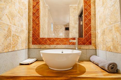 a bathroom with a large tub and a mirror at Meliora bali villa in Ubud