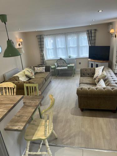 a living room with a couch and a table at Repton Cottage in the Heart of the Village in Repton