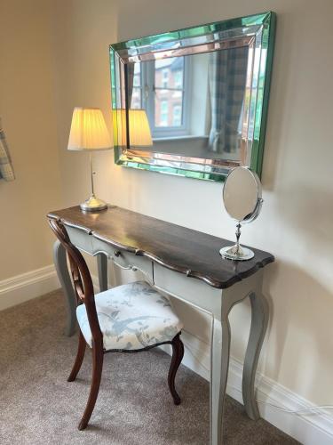 a dressing table with a mirror and a chair at Repton Cottage in the Heart of the Village in Repton