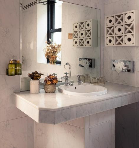a white bathroom with a sink and a mirror at The Lansdowne Kenmare in Kenmare
