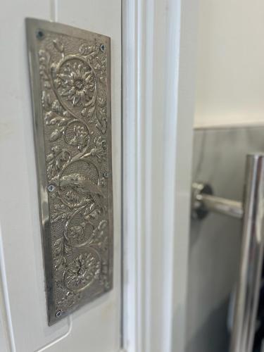 a door with a metal door knocker on a bathroom door at Repton Cottage in the Heart of the Village in Repton
