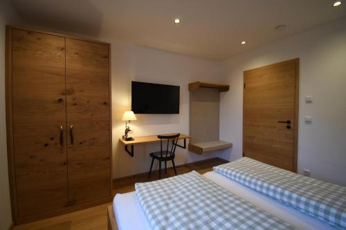 a hotel room with two beds and a desk at Alm Annerl - Neue Ferienwohnungen in Obermaiselstein in Obermaiselstein