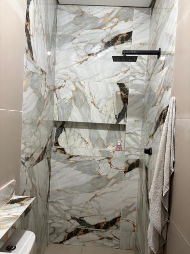 a bathroom with a shower with marble tiles at Casa Timon in Timon
